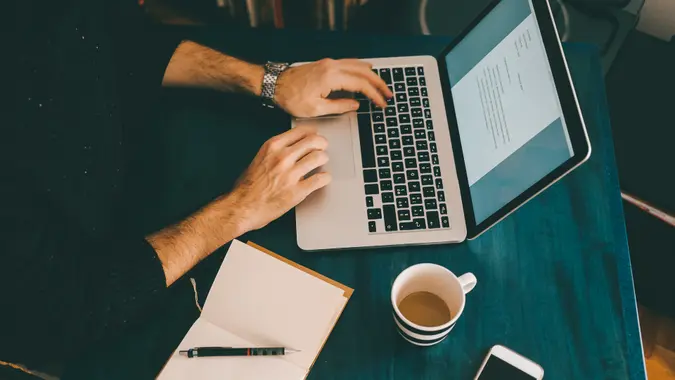 content writing se paise kaise kamaye laptop par article likhta hua freelancer
